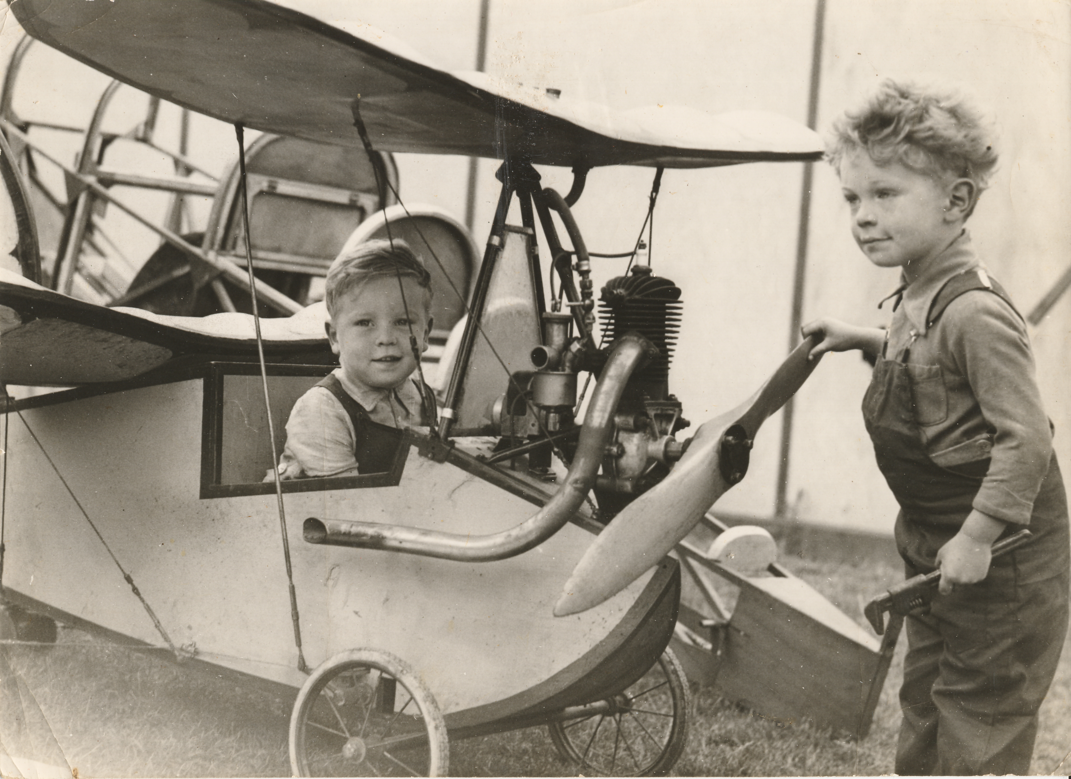 Howard Morris in the cockpit of the family's Flying Flea while his brother Eric spins the propeller, Essendon Aerodrome, 1937